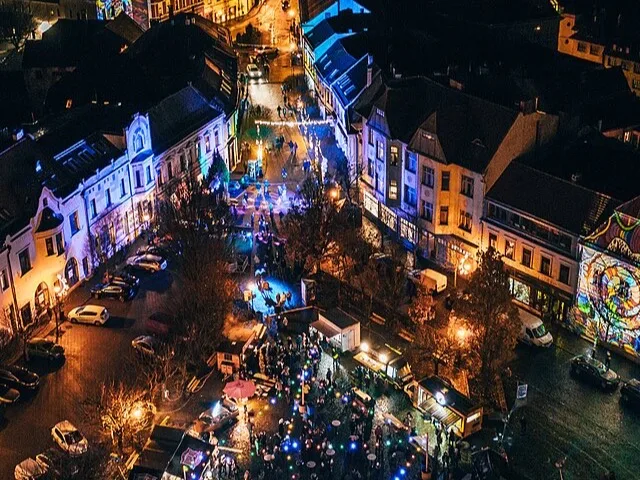 Éjszakai légi felvétel egy magyar városi kulturális fesztiválról, fényvetítéses főtérrel